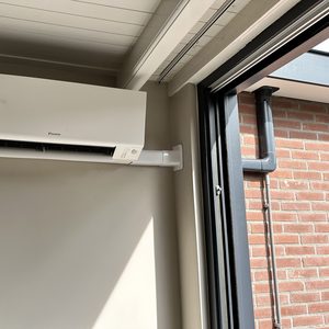 Een geïnstalleerde airconditioningseenheid aan de muur, biedt koeling voor de ruimte.