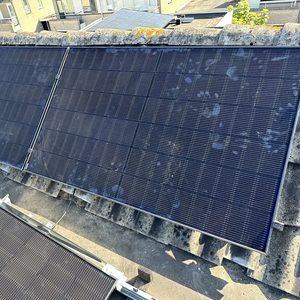 De afbeelding toont een installatie van zonnepanelen op een dak, gericht op het efficiënt opvangen van zonlicht voor energieproductie.