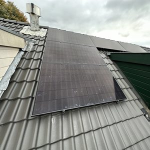 Een installatie van zonnepanelen op een hellend dak, met een moderne en strakke afwerking.