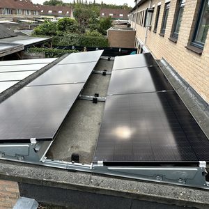 Installatie van zonnepanelen op een plat dak, gericht op het maximaliseren van zonlichtabsorptie en energieopbrengst.