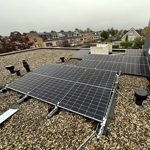 Een installatie van zonnepanelen op een dak met grind. De panelen zijn strategisch geplaatst voor optimale blootstelling aan zonlicht.