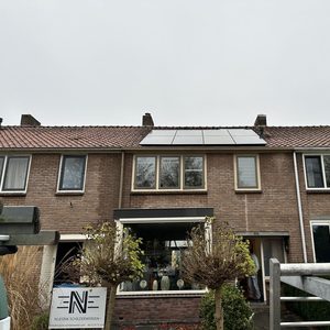 Deze installatie toont zonnepanelen op het dak van een woning, wat bijdraagt aan duurzame energieproductie.