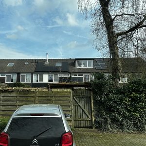 De afbeelding toont een woning met zonnepanelen op het dak, ideaal voor het opwekken van hernieuwbare energie.