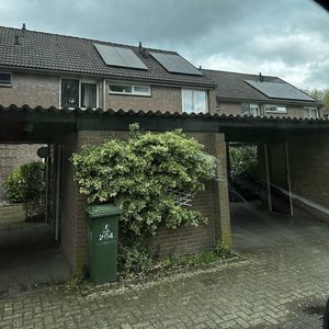 De foto toont een woning met zonnepanelen op het dak, wat duidt op een duurzame energie-installatie.