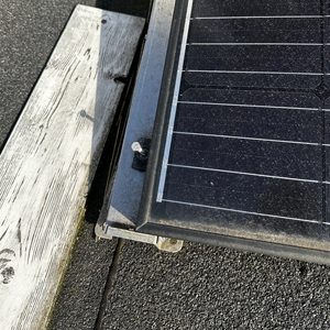 Een deel van een zonnepanelen installatie op een dak, met zichtbare bevestigingssystemen.