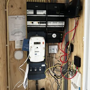 De foto toont een meterkast met bekabeling voor een laadpaal, inclusief schakelaars en een uitbreiding voor elektrische apparaten.