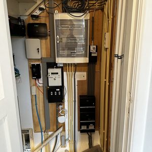 De afbeelding toont een meterkast met elektrische aansluitingen en infrastructuur voor een laadpaal installatie.