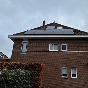 Op het dak van een woning zijn zonnepanelen geïnstalleerd om duurzame energie op te wekken.
