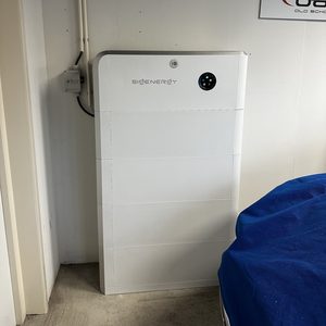 Een moderne thuisbatterij installatie die energie opslaat voor huishoudelijk gebruik, geplaatst in een nette omgeving.