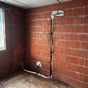 De foto toont de voorbereidingen voor een airconditioning installatie met leidingen en wandmontage voor een unit.