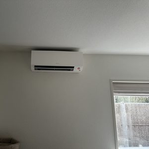 Een wandairco-installatie van het merk Fujitsu, strategisch geplaatst voor optimale luchtcirculatie in de ruimte.