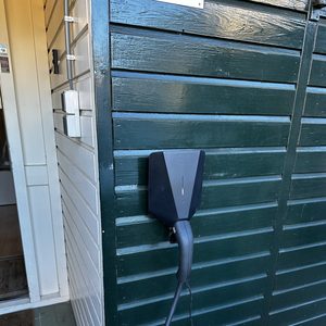 Een laadpaal is geïnstalleerd aan de buitenkant van een gebouw, geschikt voor het opladen van elektrische voertuigen.