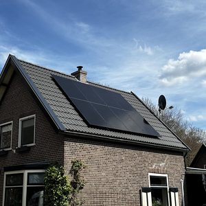 De afbeelding toont zonnepanelen die zijn geïnstalleerd op een hellend dak van een woning.