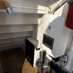 De foto toont een installatie van thuisbatterijen met een energie-opslag systeem. Apparaten zijn netjes geïnstalleerd in een beperkte ruimte.