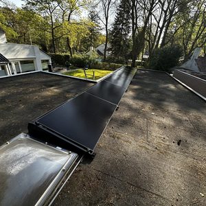 Deze installatie toont zonnepanelen op een plat dak, goed gepositioneerd voor zonlicht, om duurzame energie te genereren.