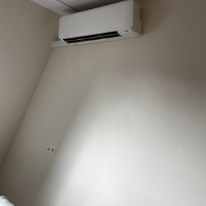 Een wandgemonteerde airconditioner die zorgt voor koeling in de kamer.