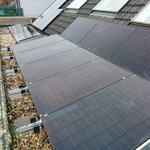 Een installatie van zonnepanelen op een hellend dak, bevestigd met montagerails. De panelen zijn gericht op het maximaliseren van zonlichtopname.