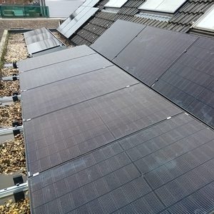 De foto toont een nette installatie van zonnepanelen op een schuine dakconstructie, optimaal gepositioneerd voor zonlicht.