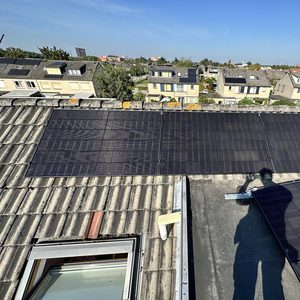 De afbeelding toont een zonnepaneleninstallatie op een dak met meerdere zonnepanelen, gericht op het opwekken van zonne-energie.