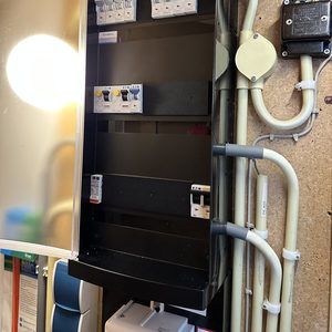 De afbeelding toont een meterkast met verschillende schakelaars en bedrading, essentieel voor de aansluiting van zonne-energie systemen.