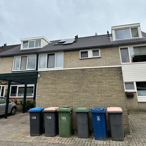 De foto toont een huis met zonnepanelen op het dak, wat wijst op een installatie voor hernieuwbare energie.