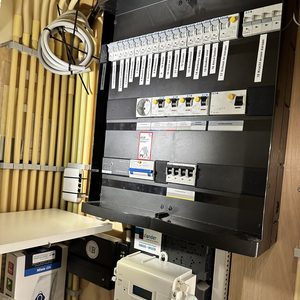 De foto toont een meterkast met bedradings voor zonnepanelen en gerelateerde apparatuur.