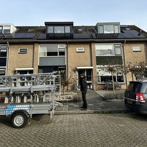 Een woning met zonnepanelen op het dak, zichtbaar vanaf de straat. De installatie is verzorgd en professioneel gepresenteerd.