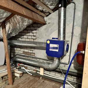 Deze afbeelding toont een installatie van luchtventilatiesystemen, met buizen en een unit voor luchtverdeling.