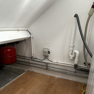 Een installatieomgeving voor zonnepanelen, met zichtbaar elektrisch paneel en leidingen. De ruimte lijkt voorbereid voor het verbinden van zonnepanelen met het elektrische systeem.