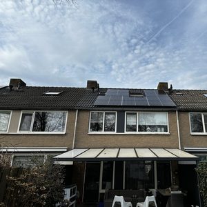 De installatie toont zonnepanelen op het dak van een rijtjeshuis, optimaal gepositioneerd voor zonlicht.