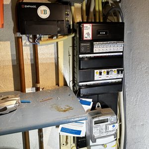 De afbeelding toont een meterkast met een inverter en aansluitingen voor zonnepanelen, wat essentieel is voor het omzetten van zonne-energie naar bruikbare elektriciteit.