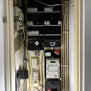 De afbeelding toont een meterkast met diverse schakelaars en apparatuur, waarschijnlijk gerelateerd aan een zonnepaneelsysteem.
