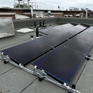 Een rijen zonnepanelen zijn geïnstalleerd op een plat dak, optimaliserend voor zonne-energieopbrengst.