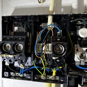 Een close-up van een meterkast met verschillende elektriciteitscomponenten en bedrading, mogelijk gerelateerd aan een zonnepaneelinstallatie.