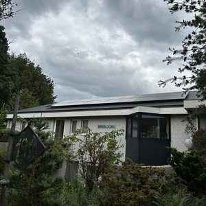 De installatie toont zonnepanelen die op het dak van een woning zijn geplaatst, om groene energie op te wekken.