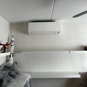 De foto toont een wandmounted airconditioningseenheid in een moderne ruimte, goed geïntegreerd met de omgeving.