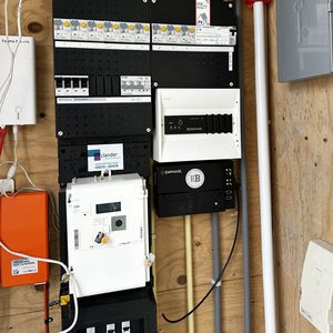 De afbeelding toont een meterkast met aansluitingen voor een airconditioningsysteem, inclusief een slimme meter en schakelaars.