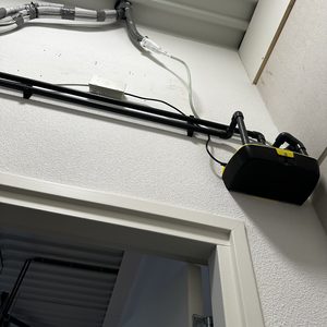 Een geïnstalleerde airconditioner met leidingen en bedrading zichtbaar aan het plafond.