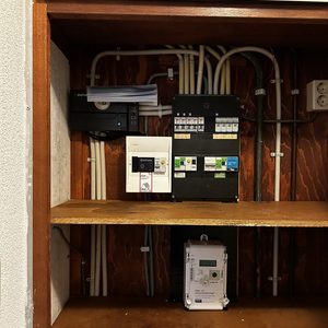 De afbeelding toont een meterkast met componenten die horen bij een airconditioninginstallatie, inclusief bedrading en besturingsapparatuur.
