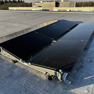 Een installatie van zonnepanelen op een plat dak, met meerdere panelen op een metalen bevestigingssysteem.