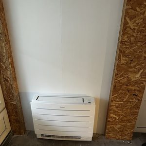 Dit is een geïnstalleerde airconditioningseenheid, klaar voor gebruik in een interieur met houten elementen.