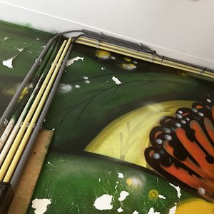 De installatie toont de leidingen en bedrading voor de airconditioning, zichtbaar tegen een kleurrijke muurschildering.