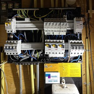 De foto toont een meterkast met verschillende elektrische componenten en bedrading, bedoeld voor de distributie van elektriciteit in een gebouw.