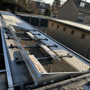 De installatie toont zonnepaneelsteunen op een plat dak, klaar voor montage van zonnepanelen.