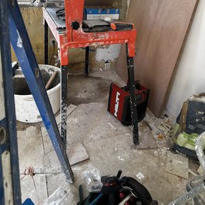 De installatie toont een meterkast die gereed is voor installatie, omgeven door bouwmaterialen en gereedschap.