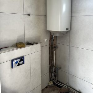 De foto toont een meterkast installatie met een verwarmingsapparaat in een semi-afgewerkte ruimte.