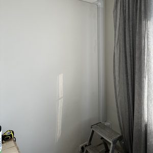 Een wandgemonteerde airconditioner geïnstalleerd boven een steiger, met leidingen langs de muur.