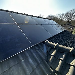 Deze installatie toont zonnepanelen die op een hellend dak zijn geplaatst, met een heldere lucht op de achtergrond.