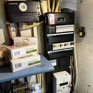 De foto toont een onderdeel van een airco-installatie met een aansturingselement en elektriciteitskabels in een meterkast.