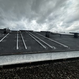 De afbeelding toont een dak met montagesystemen voor zonnepanelen, klaar voor installatie op een plat dak.